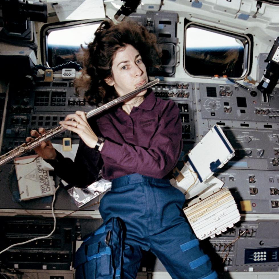 Ellen Ochoa playing the flute in space shuttle Discovery’s aft flight deck