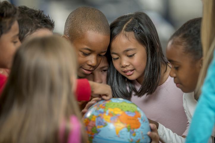 Group of diverse students looking at a globe