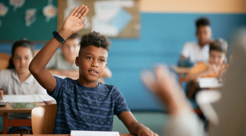 Photo of a Black student raising his hand