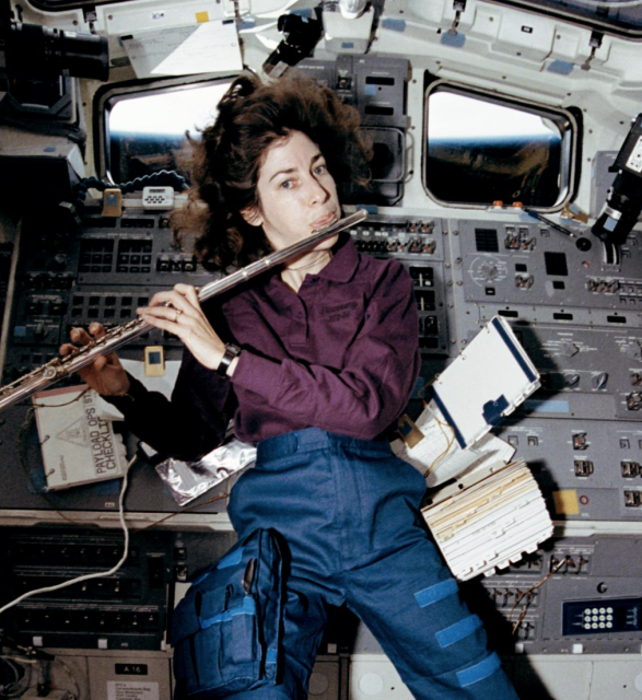 Ellen Ochoa playing the flute in space shuttle Discovery’s aft flight deck