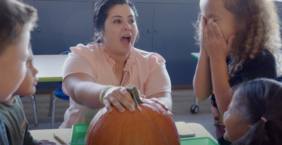 Screenshot from the video: students doing a halloween activity with a teacher